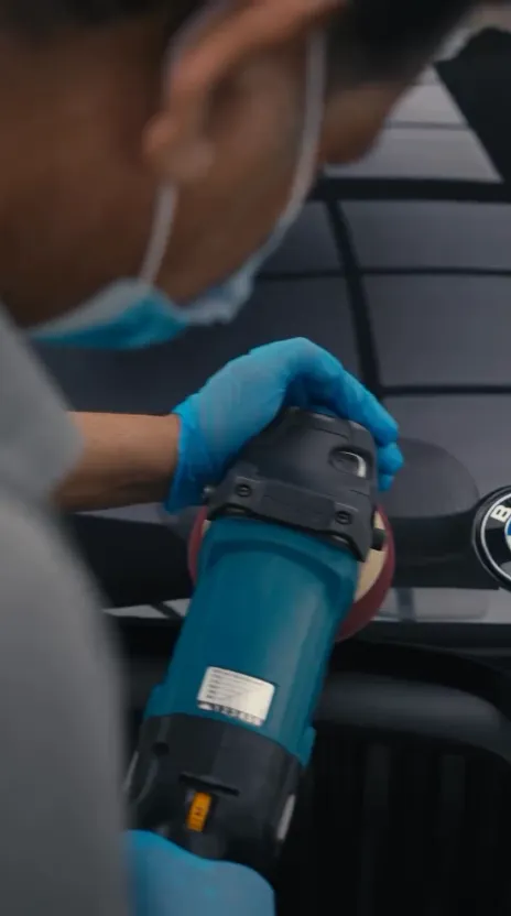 OFJ detailer polishing a black BMW X5 M
