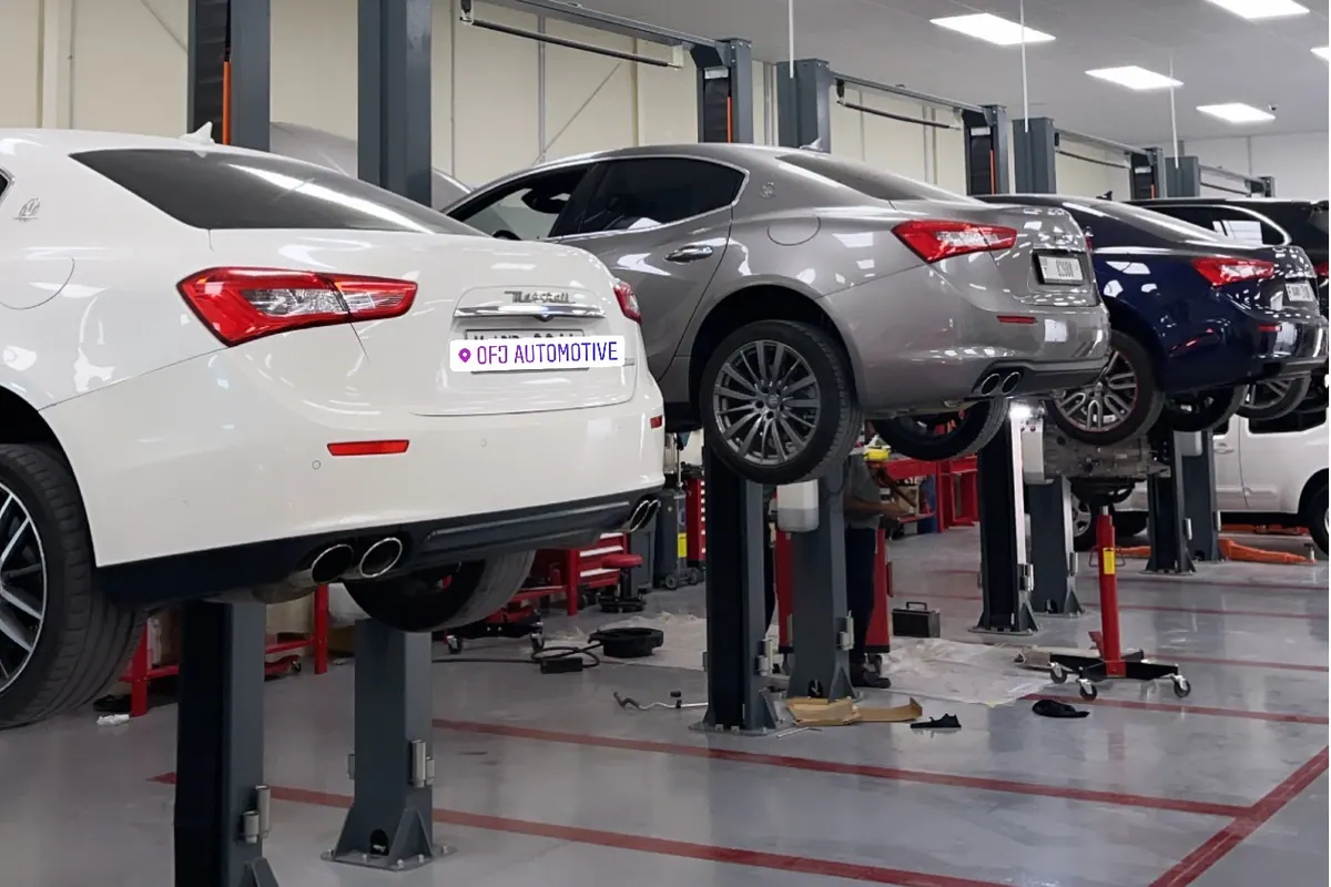 White, grey and blue Maserati Ghiblis on the lifts at OFJ Automotive, Al Quoz, Dubai