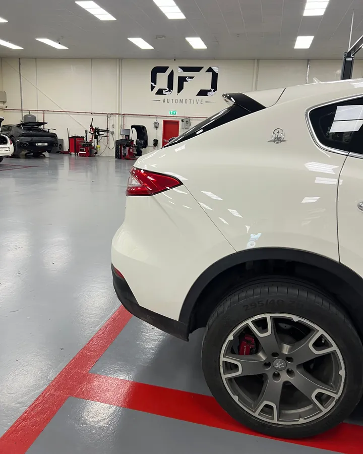White Maserati Levante under the OFJ Automotive logo in the Al Quoz workshop, Dubai