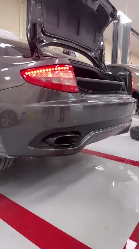 Rear of a water-damaged grey Maserati with the boot open at OFJ Automotive