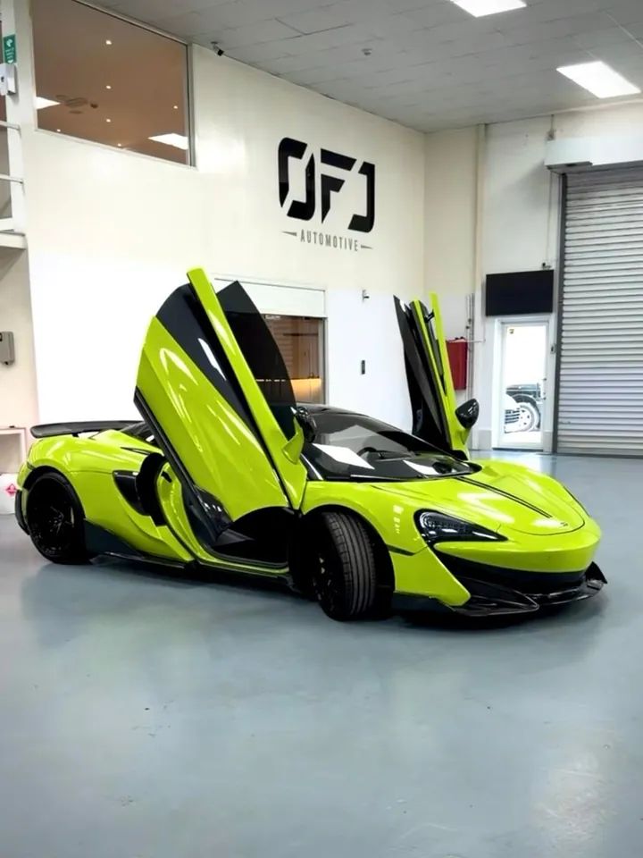 Lime green McLaren 600LT with its doors open in the OFJ Automotive showroom