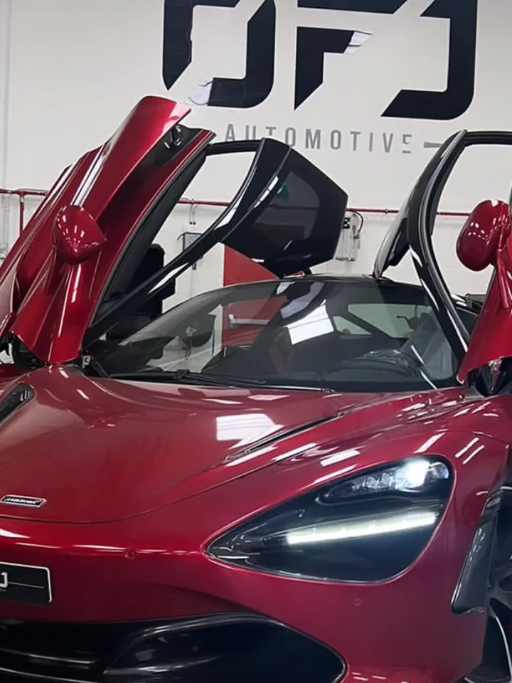 Red McLaren 720S with its dihedral doors open at OFJ Automotive