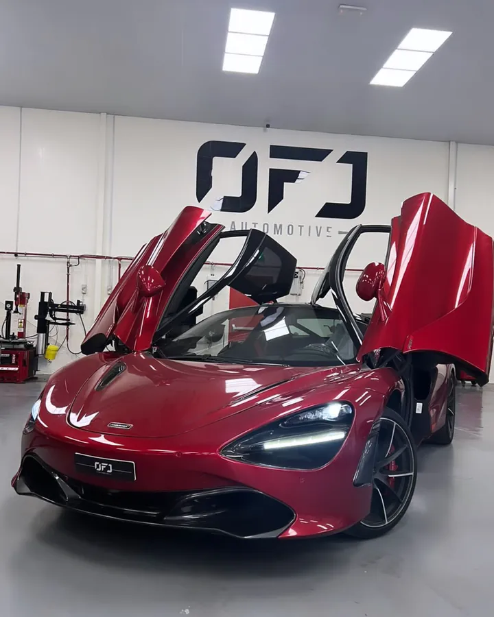 Red McLaren 720S with its doors open under the OFJ Automotive logo, Dubai