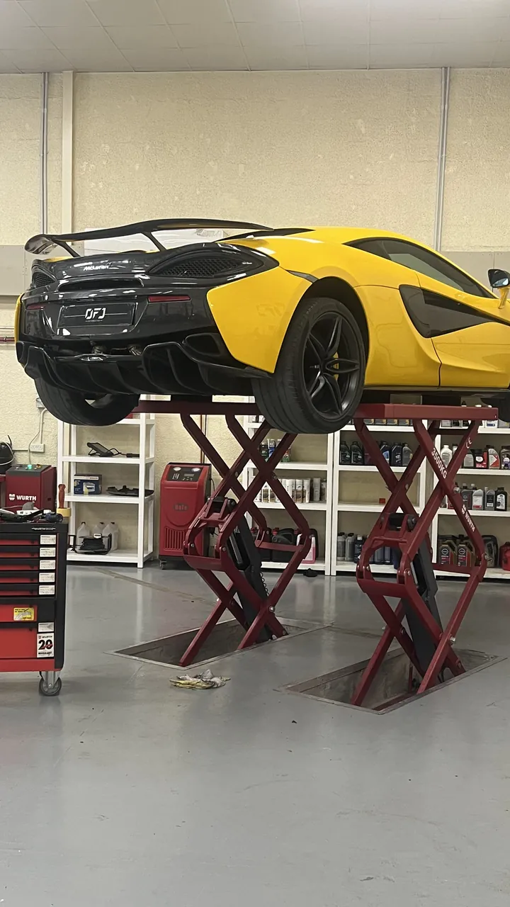 Yellow McLaren raised on a lift in the OFJ Automotive workshop, Dubai