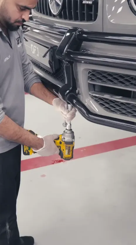OFJ technician working on the front of a Mercedes-AMG G 63 during an accident repair
