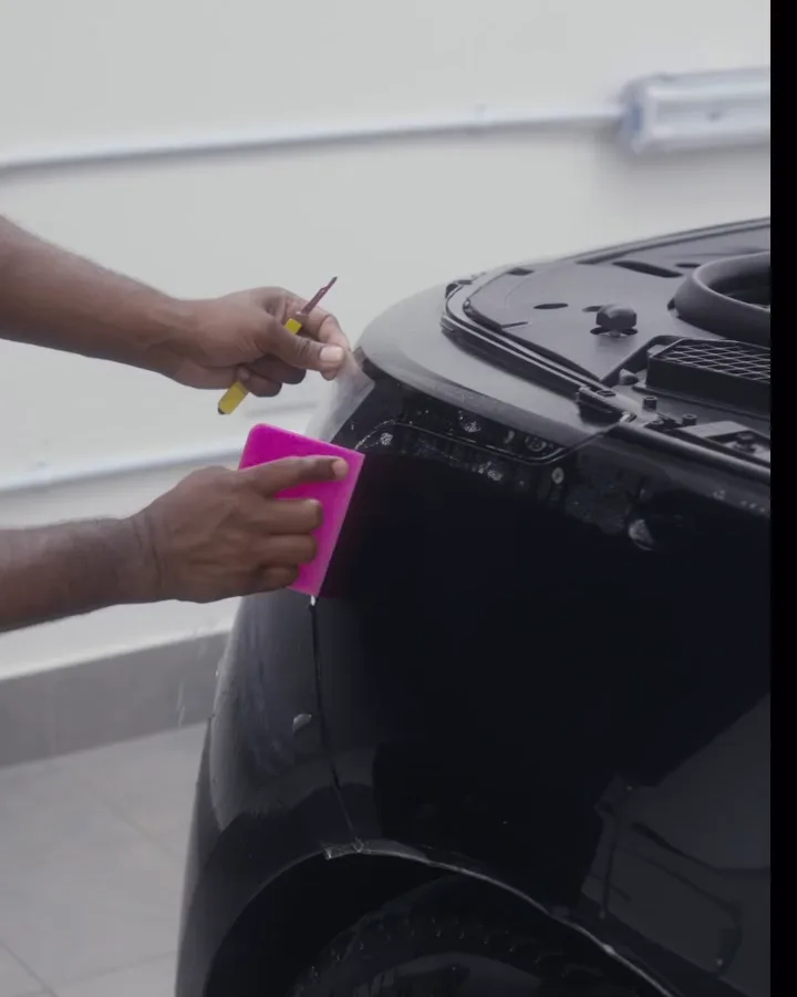 OFJ installer fitting paint protection film on a black Range Rover wheel arch