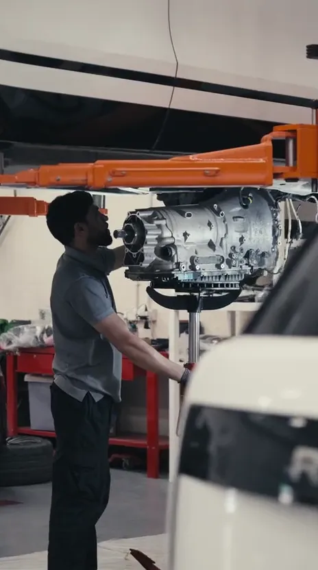 OFJ technician lowering a Range Rover gearbox on a transmission jack